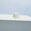 Golden ring with transparent bear pendant and gold star details on a white pedestal - Ring / Clear