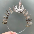 Detailed view of silver crescent moon decor and raw crystal stones on handmade headband - Brown