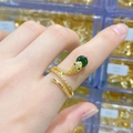 Macro detail of a gold snake ring with green gemstone head and white zircon pave setting - Large Green Main Stone Gold Snake Open Ring