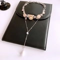 Detalle de collar largo de borlas con colgantes de sol dorados y perlas elegantes - Oro y Plata