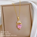 Nahaufnahme von rosa Herzanhänger mit Kronendesign und Kristallen an goldener Halskette - Rosa Krone Herz (H123)