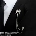 Détail de la broche ailes d'ange en argent avec chaînes et strass sur un costume - Style Ailes d'Ange Argentées (TL24011)