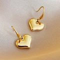 Eleganti orecchini a cuore in oro 14k presentati su pregiato tessuto di seta champagne - Oro