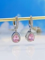Detailed view of pear-shaped pink crystal halo earrings with silver setting on stand - Pink