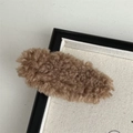 Gros plan détaillé d'une pince à cheveux en peluche marron à texture douce - Café Clair