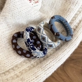 Gros plan de quatre chouchous en maille épaisse aux motifs floraux vintage et textures variées - Série Bleu et Marron (Lot de 4)