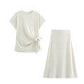 Detalle del conjunto de punto crema con top anudado al cuello y falda midi de línea A - S / Marfil
