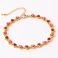 Detail of gold evil eye heart bracelet with red enamel and zircon stones on a white base - 18K Gold / Red
