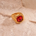 Close-up of a vintage gold ring with a square red zircon set on a textured stone - Red