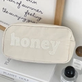 Détail d'une pochette en nylon crème avec broderie honey et fermeture éclair dorée - Gris Pâle