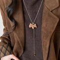 Gros plan du collier avec pendentif poney floqué marron et chaîne dorée sur mannequin - 54# Collier-Or-Cheval marron floqué