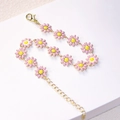 Detailed macro view of daisy flower bracelet with pink and yellow enamel and gold clasp - Light Pink