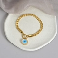 Bracciale a catena cubana dorata con ciondolo Occhio del male su un piatto bianco strutturato - Bracciale