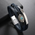 Dettaglio del bracciale in pelle blu intrecciata con fiore d'argento e turchese - Blu