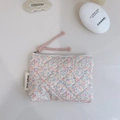 Detailed close-up of quilted floral coin purse with zipper and simple wish label - Light Pink Purple Floral