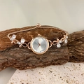 Elegant rose gold butterfly bracelet watch with blue accents on textured stone base - White
