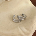 Dettaglio di orecchini a C a tre strati in argento su un piatto decorativo in ceramica - Argento (DEP389)