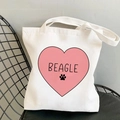 White canvas tote bag featuring pink heart Beagle Yoga print on a black iron chair - Pink Heart Beagle