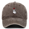 Detailed view of white finger heart embroidery and red heart on vintage washed baseball cap - Coffee