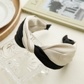 Detail of a wide twisted headband in black and cream satin fabric on a glass box - Black & White