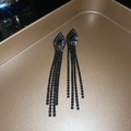 Macro shot of black tassel earrings with rhinestones on a gold tray with starburst light - Eye Tassel Style (4# Gun Black Silver Needle)