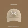 Detailed close-up of khaki sun hat featuring white butterfly embroidery and premium cotton fabric - Front Bowknot Embroidery Baseball Cap / Khaki