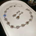 Sparkling silver teardrop crystal necklace and earring set on a white ceramic plate - Silver 2-Piece Set / Silver