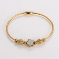 Primer plano de una pulsera de cable dorado con un dije floral decorado con cristales finos - Dorado