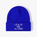 Close-up of LEAVE ME ALONE white embroidery on navy blue ribbed knit beanie hat - One Size / Sapphire Blue