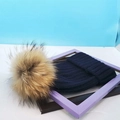 Dunkelblaue Strickmütze für den Winter mit großem braunem Pelzbommel als Detail - Einheitsgröße / Marineblauer Hut Mit Waschbärpelz Bommel