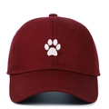 Close-up of a white paw embroidery on a burgundy cotton baseball cap with twill texture - One Size / Burgundy
