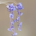 Detailed macro view of purple chiffon floral earrings with matching bead tassel accents - Purple