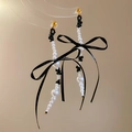 Dettaglio di orecchini a nappa con perle e fiocchi neri con finiture dorate - Fiocco Nero (Perno in Argento)