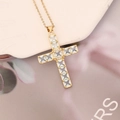Macro shot of gold cross necklace with micro-paved cubic zirconia stones and shiny finish - Light Blue