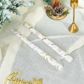 Detail of Christmas tapered candles with Santa and tree prints on a golden holder - Christmas Berry (White)