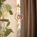 Close-up of golden suncatcher with natural crystals creating rainbow light reflections - Fluorite Stone Circle