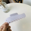 Macro view of light purple fish-shaped hair claw clip with unique bone-style teeth - White Mackerel