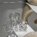 Detailed macro view of clear acrylic hair claw clip showing internal metal spring mechanism - Clear White
