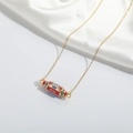 Detail of gold enamel cylinder pendant necklace with Evil Eye pattern and WILL engraving - Red