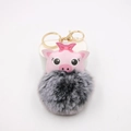 Dettaglio di un portachiavi a forma di maialino rosa con pompon grigio e anello dorato - Nero Bicolore