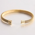Brazalete rígido de malla dorada de 7mm con forma de C y extremos pulidos sobre fondo blanco - Dorado