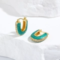 Détail macro de boucles d'oreilles dorées en U avec émail vert et zircons blancs - Vert