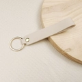Minimalist beige leather keychain with gold ring and rivet on a wooden plate - No.13 Ivory