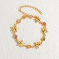 Bracciale in acciaio inossidabile dorato con fiori in zircone colorati e stelle su fondo bianco - Pentagramma / Oro