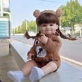 Lifelike 55cm reborn doll in brown bear knit outfit with pigtails sitting on a bench - Brown Bear Knit Romper Smiling Face / Doll Clothes (Outfit Only)
