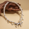 Dettaglio della collana di perle con ciondolo a pony argento e stelle su legno - Collana - Argento