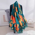 Dettaglio di un grande foulard in seta verde scuro con vivaci motivi floreali arancioni - Verde