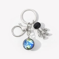 Dettaglio del ciondolo astronauta e sfera terrestre blu su portachiavi in metallo argento - Terra Blu-7