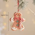 Gingerbread man ornament with red bow and candy cane on pine branch, 10cm height - Red Bow Gingerbread Man