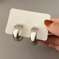 Detail of silver-finish C-shape hoop earrings with 925 silver posts on a display card - Silver